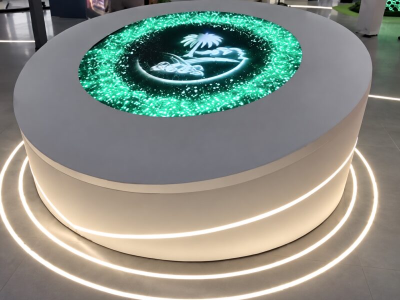 طاولة عرض LED دائرية مضاءة مع الشعار الظاهر وسط الشاشة الخضراء